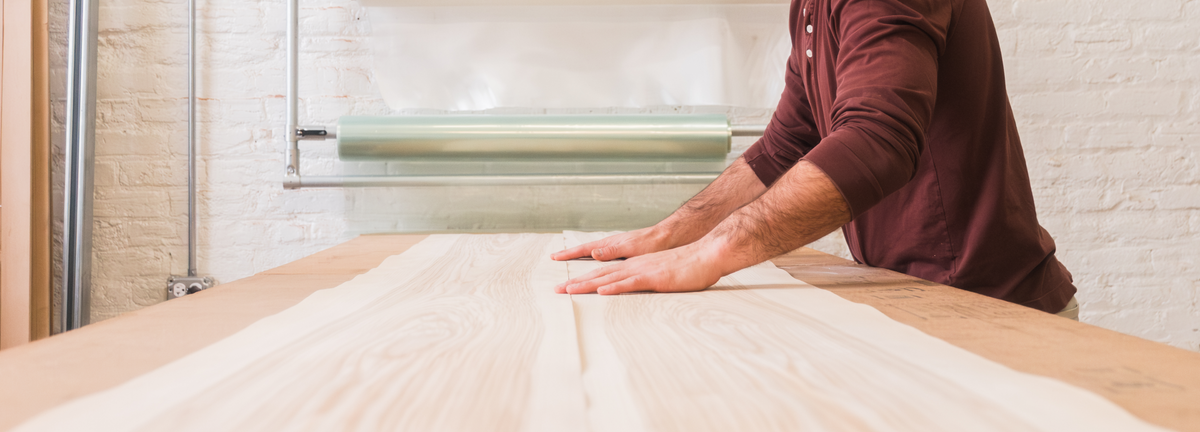Hands shaping a board in the workshop