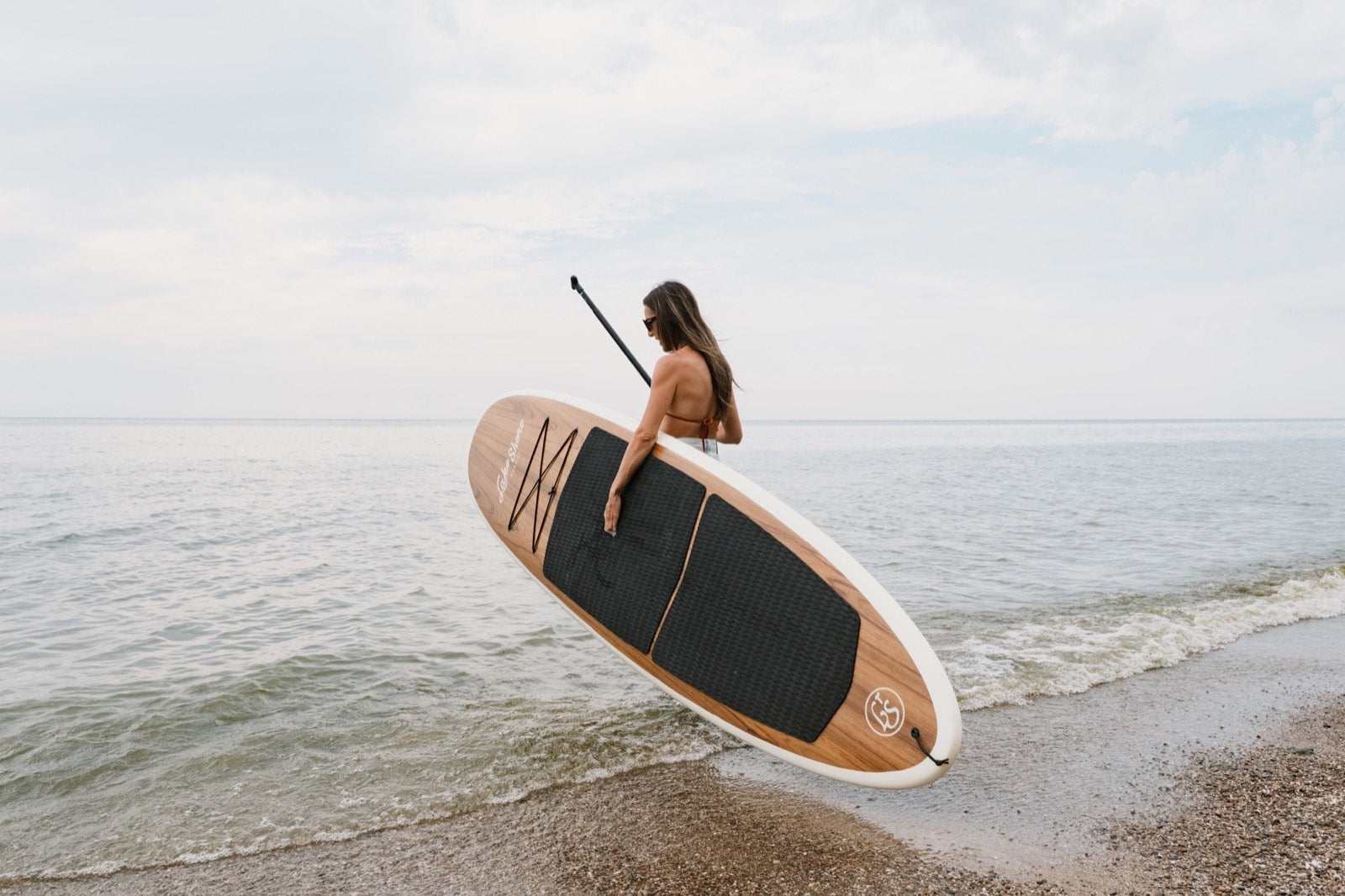 Carrying a wood paddle board into Lake Michigan at Lake Shore Resort